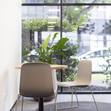 Jac chairs for a breakout space where casual meetings can happen. They are rey in colour and the background has greenery to bring biophilic element to the space.