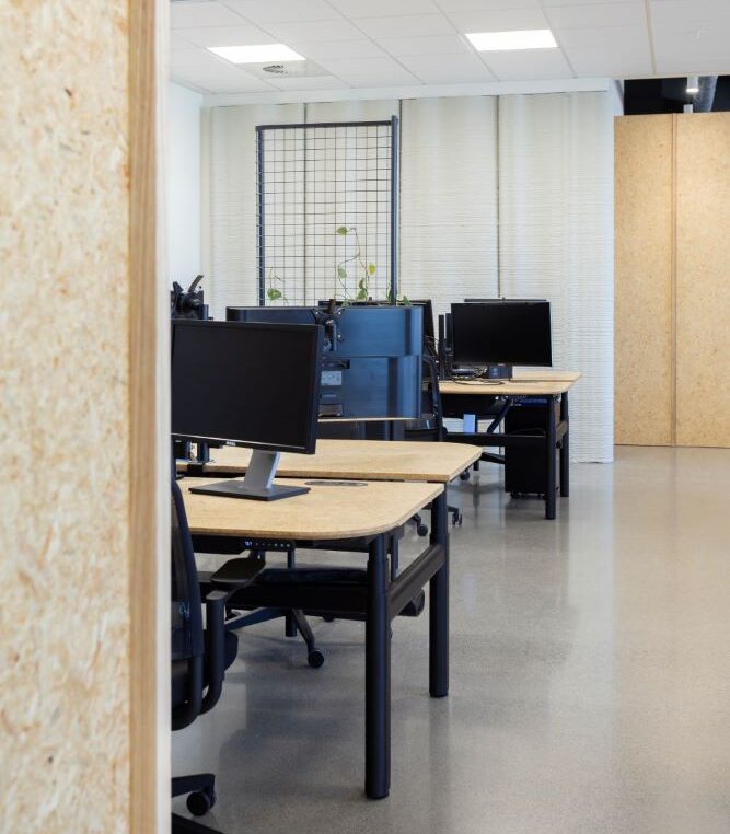 an open plan office space with desks, and ergonomic office chairs,in a line